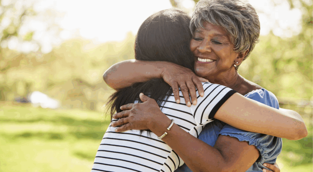 Woman embracing another woman in a park, symbolizing the emotional connection and complexities of adult adoption in Texas.