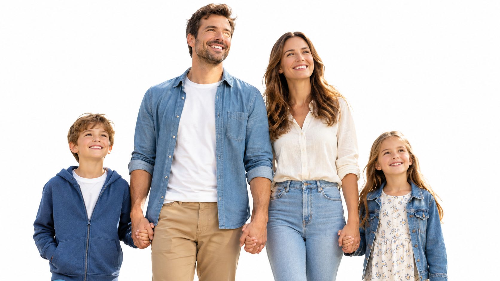 A happy smiling family of four standing together against a white background looking towards the sky.
