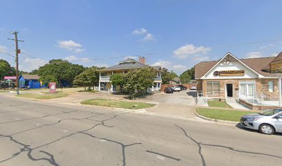Fort Worth office location of the Law Office of Bryan Fagan, featuring a two-story building surrounded by trees and parked cars, with a clear blue sky above.