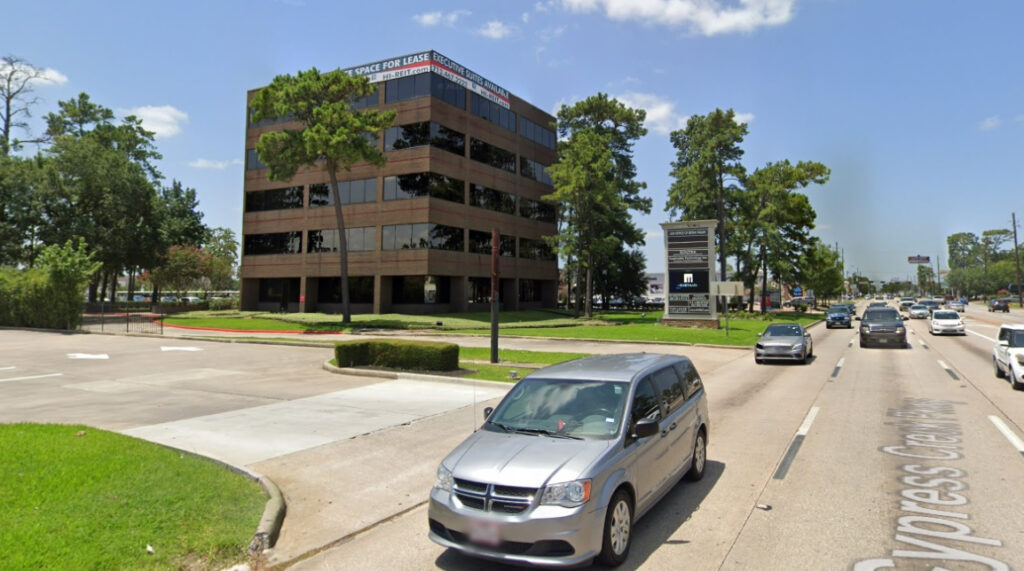 Houston office building of the Law Office of Bryan Fagan, featuring "Space for Lease" signage, surrounded by trees and traffic on Cypress Creek Parkway.